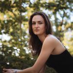 Femme au regard assuré dans la nature, illustrant la capacité à prendre sa place avec plus de justesse et de confiance